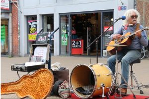 Straatmuzikant Moti op zijn vaste stek in de Herestraat